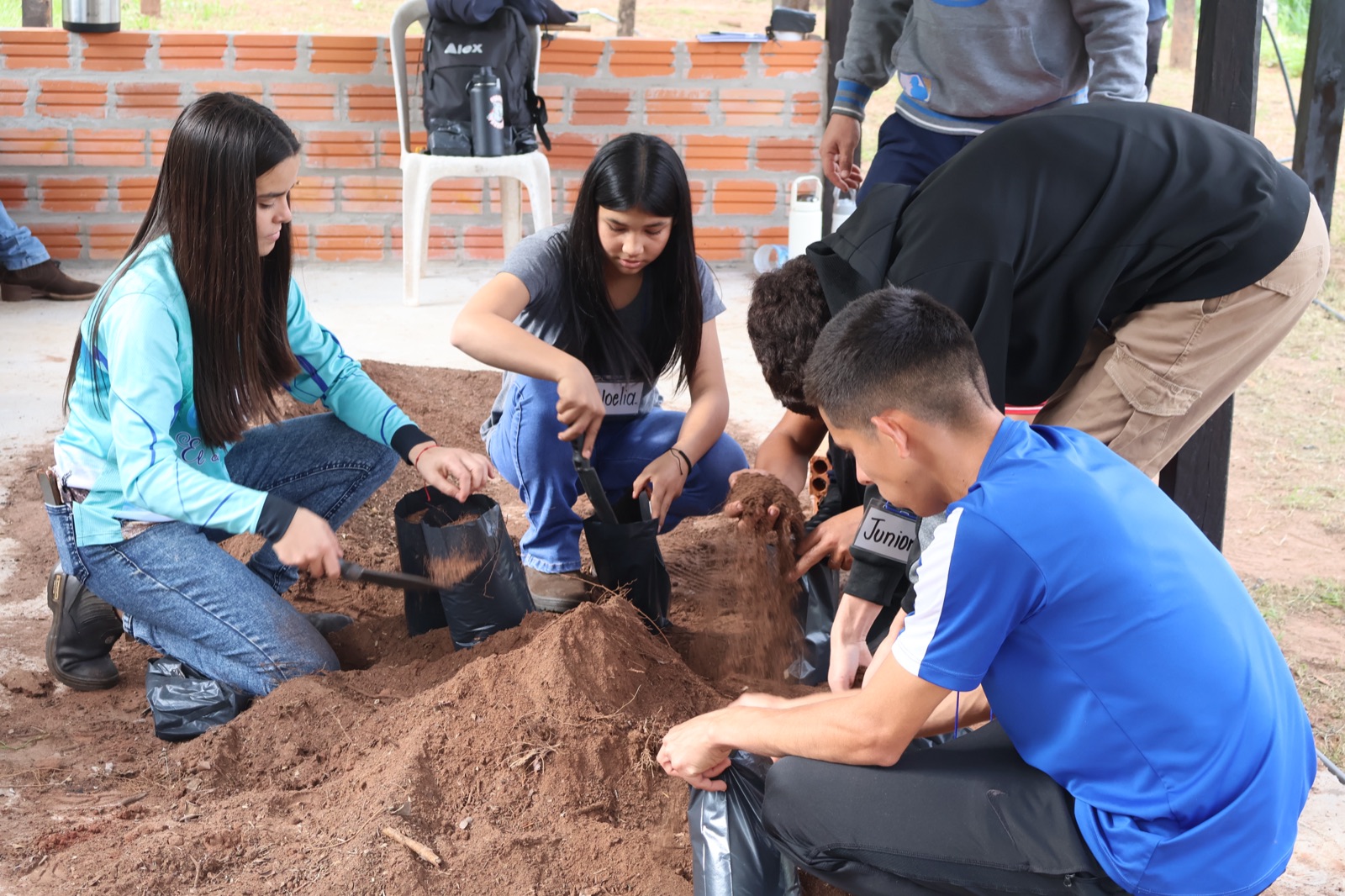 Jóvenes preparando sustratos y cargando macetas durante los talleres vivenciales